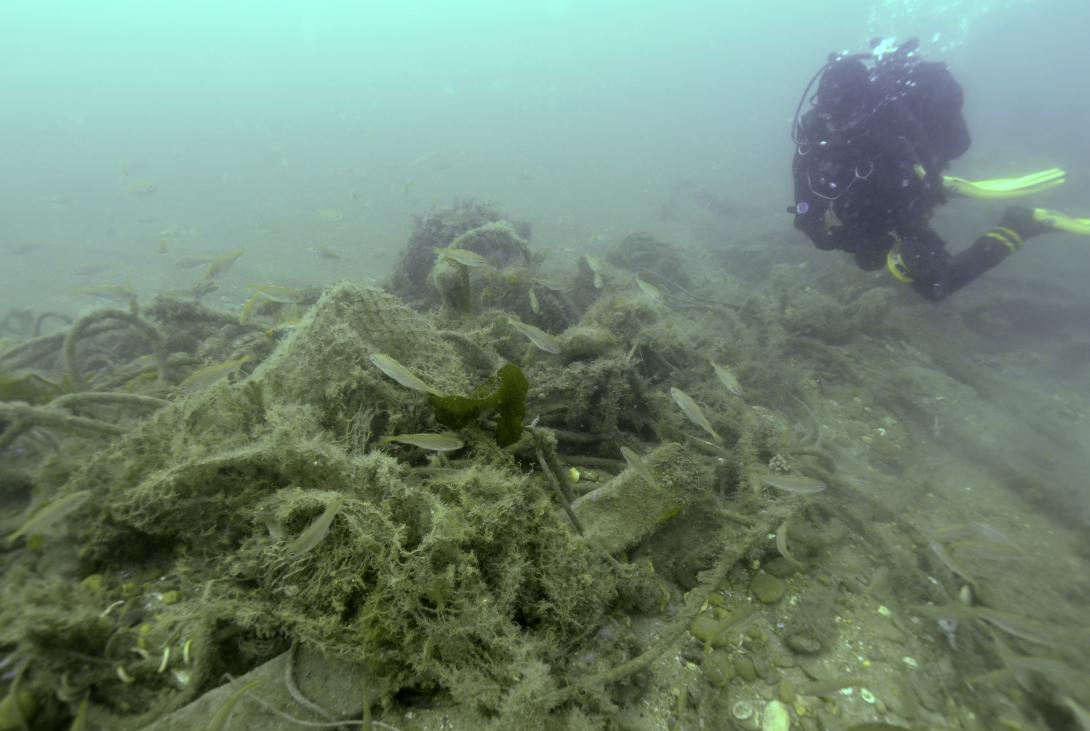 image of a scuba diver and rubbish on the seabed